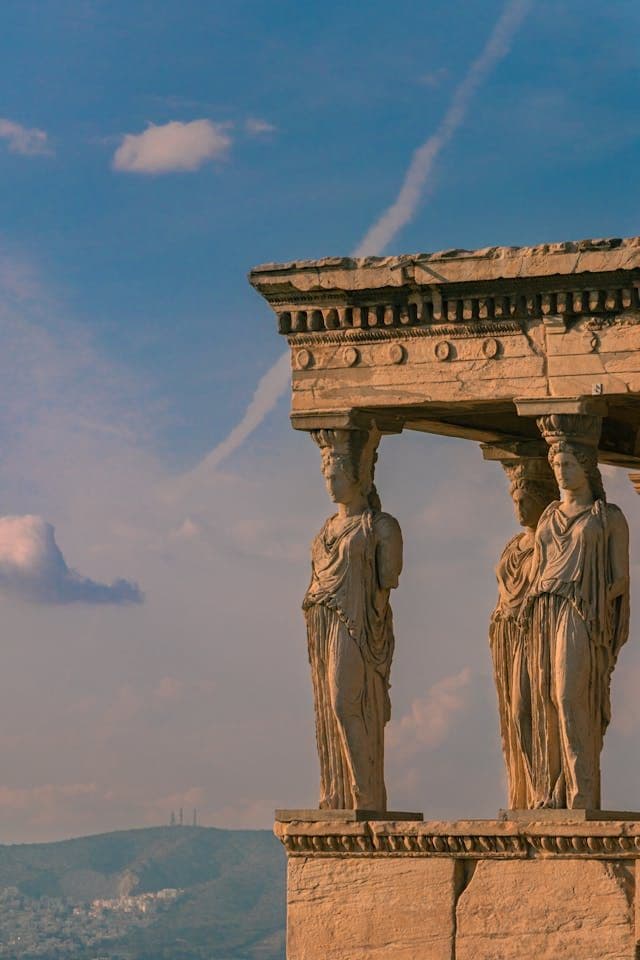 Decaying greek building with statues of women holding up the ceiling