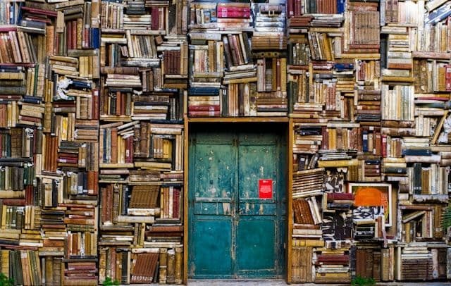 A blue door set into a wall of old fashioned and vintage books